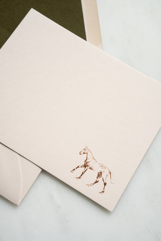 Photo of a copper foil stamped correspondence card featuring a tiny drawing of a horse cantering by equine artist Danielle Demers.