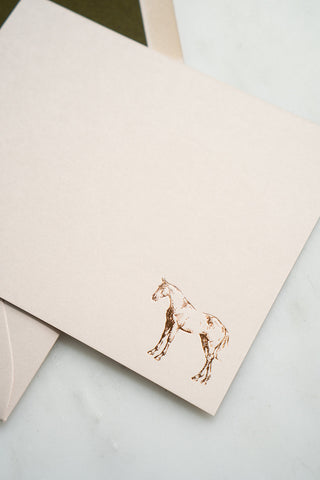 Photo of a copper foil stamped correspondence card featuring a tiny drawing of a horse standing by equine artist Danielle Demers.
