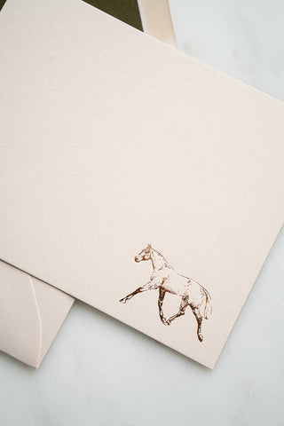 Photo of a copper foil stamped correspondence card featuring a tiny drawing of a horse trotting by equine artist Danielle Demers.