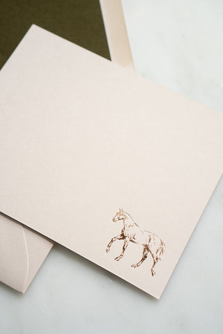 Photo of a copper foil stamped correspondence card featuring a tiny drawing of a horse walking by equine artist Danielle Demers.