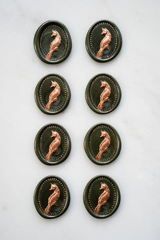 Photo of a set of 8 metallic forest green fox wax seals with copper painted details by Danielle Demers