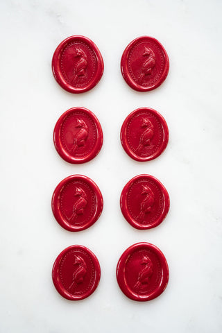 Photo of a set of eight metallic Christmas red wax seals featuring a three-dimensional intaglio impression of a fox designed by equine artist Danielle Demers