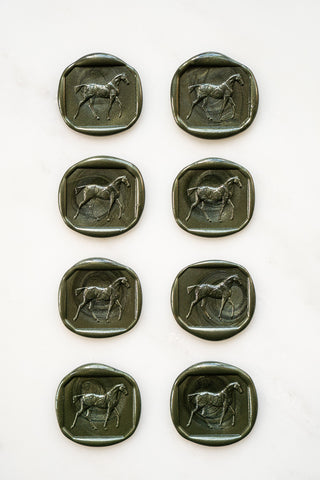 Photo of a set of 8 metallic forest green wax seals featuring a walking horse design by Danielle Demers.