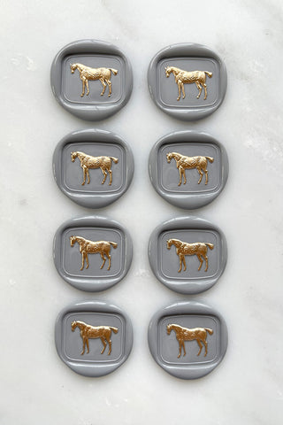 Photo of a set of 8 grey standing horse wax seals with gold hand painted details by Danielle Demers