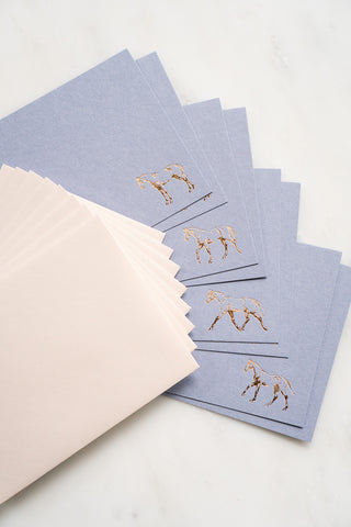 Photo of a set of 8 gold foil stamped correspondence cards featuring drawings of horses standing, walking, trotting, and cantering by equine artist Danielle Demers