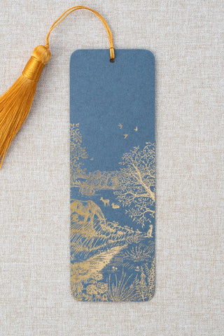 A foil stamped bookmark featuring a countryside summer scene with a horse, flowers, deer, a stoat, birds, butterflies and a bee. Printed in gold foil on French Blue card stock and finished with a Gamboge yellow tassel.