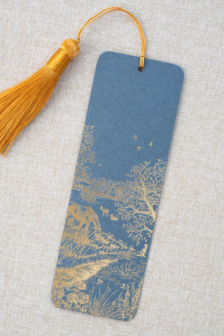 A foil stamped bookmark featuring a countryside summer scene with a horse, flowers, deer, a stoat, birds, butterflies and a bee. Printed in gold foil on French Blue card stock and finished with a Gamboge yellow tassel.