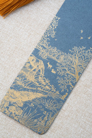 A foil stamped bookmark featuring a countryside summer scene with a horse, flowers, deer, a stoat, birds, butterflies and a bee. Printed in gold foil on French Blue card stock and finished with a Gamboge yellow tassel.