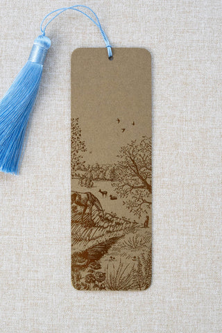 A foil stamped bookmark featuring a countryside summer scene with a horse, flowers, deer, a stoat, birds, butterflies and a bee. Printed in bronze foil on walnut card stock and finished with a sky blue tassel.