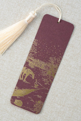 A foil stamped bookmark featuring a countryside winter scene with a horse, goose, hedgehog, robin and red squirrel. Printed in gold foil on a deep maroon card stock and finished with a cream tassel.