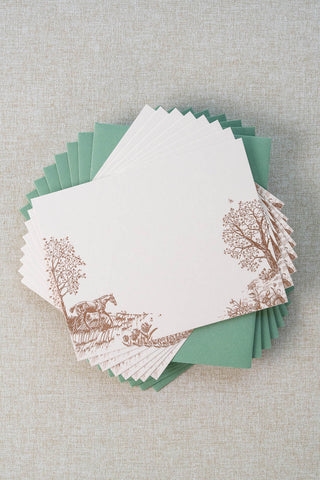 Set of eight foil stamped correspondence cards featuring a spring scene with a horse, rabbits, tulips, daffodils, trees and butterflies. Rose gold foil design on cream card stock with a green envelope lined in a blush pink liner.
