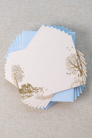 Set of eight foil stamped correspondence cards featuring a summer scene with a horse, deer, lavender, roses, trees and birds. Gold foil design on cream card stock with a light blue envelope lined in a muted moss green liner.