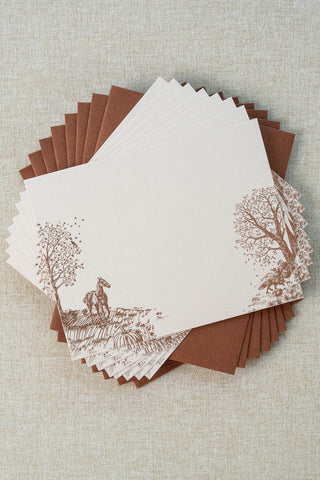 Set of eight foil stamped correspondence cards featuring an autumn scene with a horse, fox, pumpkins, a pheasant, trees and a crow. Rose gold foil design on cream card stock with a sienna brown envelope lined in a deep teal liner.