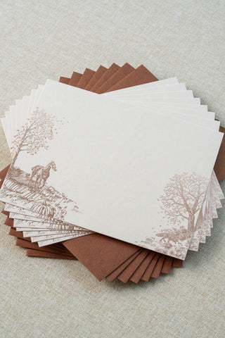 Set of eight foil stamped correspondence cards featuring an autumn scene with a horse, fox, pumpkins, a pheasant, trees and a crow. Rose gold foil design on cream card stock with a sienna brown envelope lined in a deep teal liner.