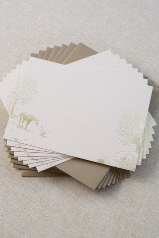 Set of eight foil stamped correspondence cards featuring a winter scene with a horse, goose, hedgehog, robin, trees and snow. Gold foil design on cream card stock with a taupe envelope lined in a deep cranberry liner.