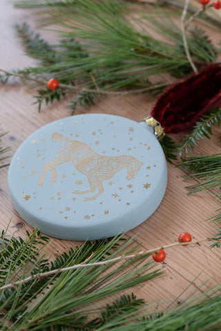 PRE-ORDER: "Snow Day" Block-Printed Horse Motif Ceramic Ornament – Snowlight Blue & Gold with Garnet Ribbon