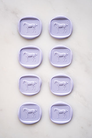 Photo of a set of 8 lavender wax seals featuring a standing horse design by Danielle Demers.