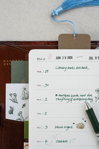 Washi paper stickers used in a Filofax planner page layout. Close up of planner page. Washi paper sticker sheet featuring delicate illustrations of horses, wildlife and flowers tucked in a pocket of the planner, a foil stamped horse motif bookmark marks the page and a pen sits above.