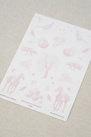 Danielle Demers washi paper sticker sheet on a light beige textured fabric background. The sticker sheet features delicate pink illustrations of horses, countryside animals, and flowers.