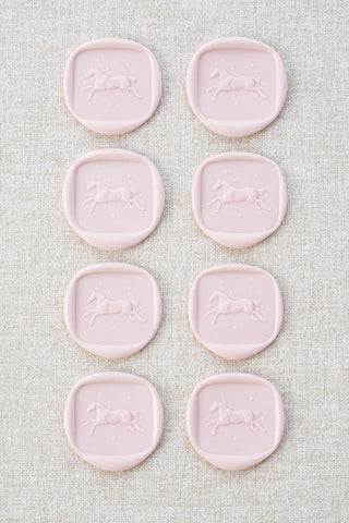 Set of eight light pink wax seals with a horse and stars motif 
