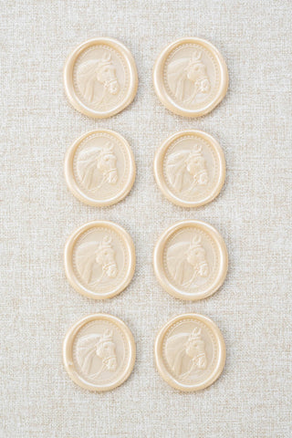 Set of eight light metallic off-white wax seals with a horse head motif 