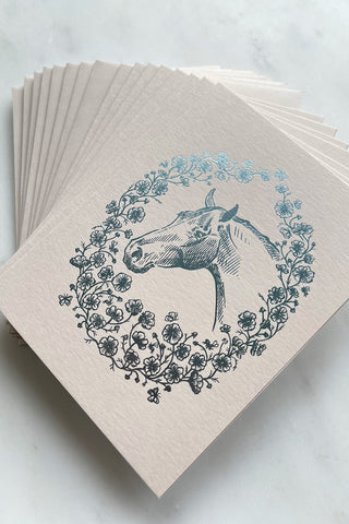 Set of eight silver blue metallic foil stamped note cards, featuring a drawing of a horse in a wreath of cosmos flowers, bees and butterflies, on cream 111lb card stock by equine artist Danielle Demers.