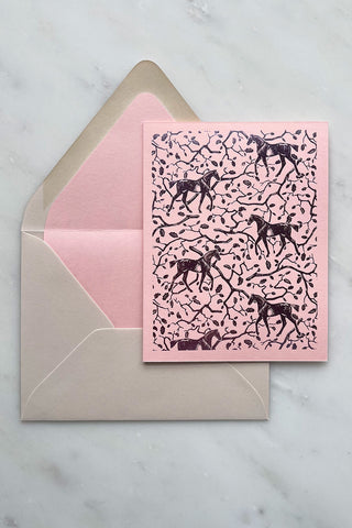 Photo of a foil-stamped note card featuring a horse and oak leaf and branch pattern printed in metallic lilac foil on a soft pink card stock by equine artist Danielle Demers.