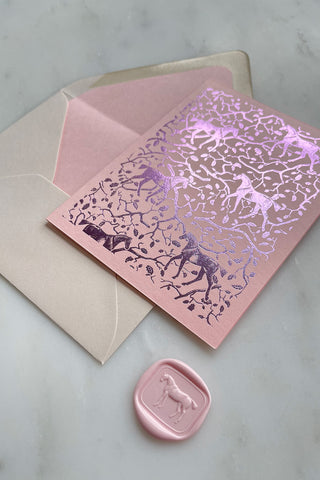 Photo of a foil-stamped note card featuring a horse and oak leaf and branch pattern printed in metallic lilac foil on a soft pink card stock by equine artist Danielle Demers.