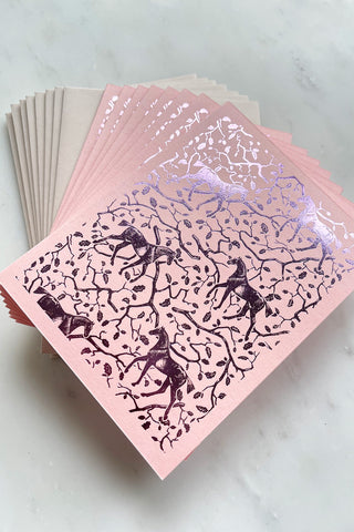 Photo of a set of eight foil-stamped note cards featuring a horse and oak leaf and branch pattern printed in metallic lilac foil on a soft pink card stock by equine artist Danielle Demers.