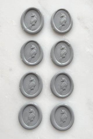 Photo of a set of eight grey wax seals featuring fox designs created by equine artist Danielle Demers