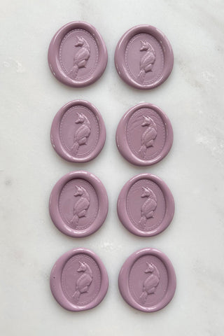 Photo of a set of eight dusty rose wax seals featuring fox designs created by equine artist Danielle Demers