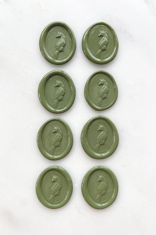 Photo of a set of eight sap green wax seals featuring fox designs created by equine artist Danielle Demers
