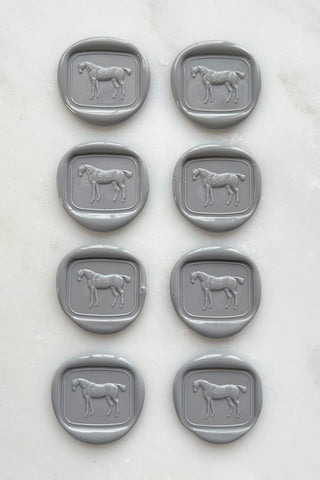 Photo of a set of 8 grey wax seals featuring a standing horse design by Danielle Demers.