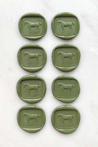 Photo of a set of 8 sap green wax seals featuring a standing horse design by Danielle Demers.