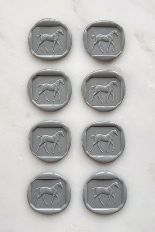Photo of a set of 8 grey wax seals featuring a walking horse design by Danielle Demers.