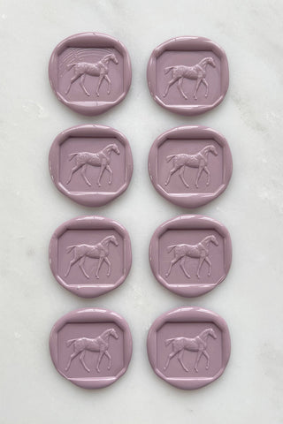 Photo of a set of 8 dusty rose wax seals featuring a walking horse design by Danielle Demers.